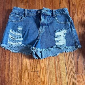 Medium to dark wash jean shorts with some rips.